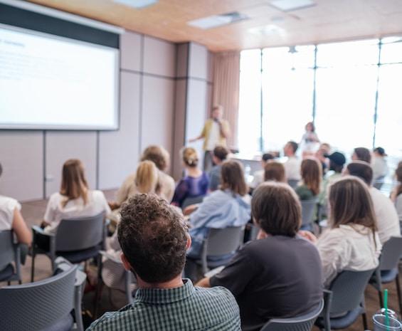 Classroom full of professional listening to an expert giving a lecture