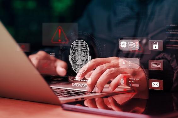 Photo of an individual typing. graphic design elements of a digital face, security shield and warning sign on top