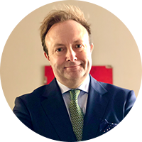 Older business man in a suit with a green tie