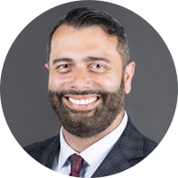 Business man with a beard wearing a black suit , white top and red tie
