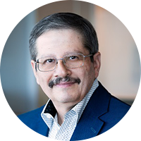 Older business man with glasses wearing a blue suit and checked top