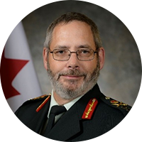 Man with glasses wearing a military suit with a black tie