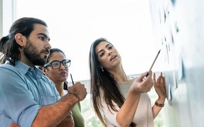 Photo of a diverse group of people working on a smart board