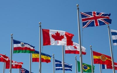 Photo of clear blue sky and flags from different nations.