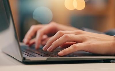 White person typing on a laptop