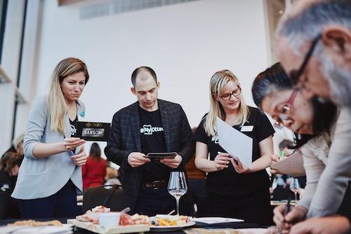 Group of diverse individuals working together around a table to find clues