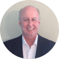 Older bald white man in a suit smiling