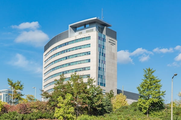 A landscape image of the uOttawa Desmarais building with trees in the foreground